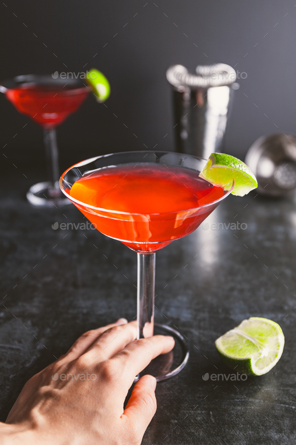 Download Red cocktail with lime in Martini glass on a table. Stock Photo by Edalin