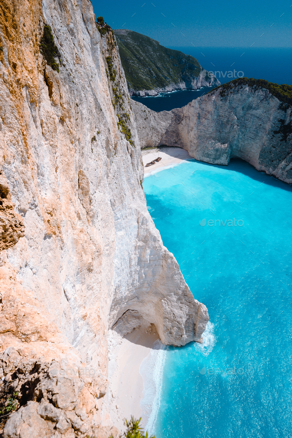 Limestone chalk colored like huge cliff rocks surrounding Navagio beach with Shipwreck and azure - Stock Photo - Images
