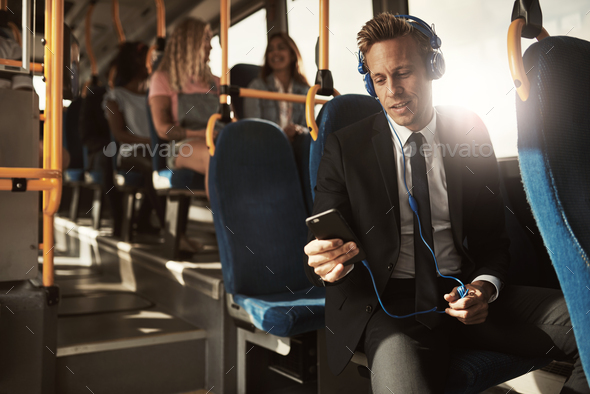 Young businessman listening to music on his morning commute