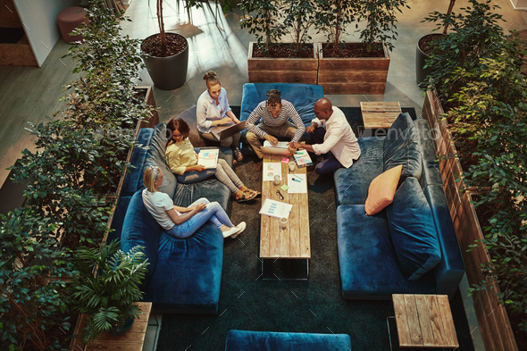Diverse group of businesspeople meeting together in an office lounge