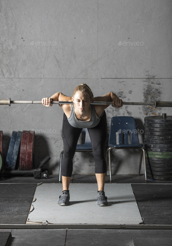 Strong young woman warming up in preparation for heavy lifting in gym ...