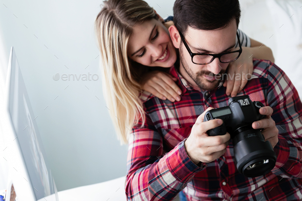 Young couple of designers using digital camera