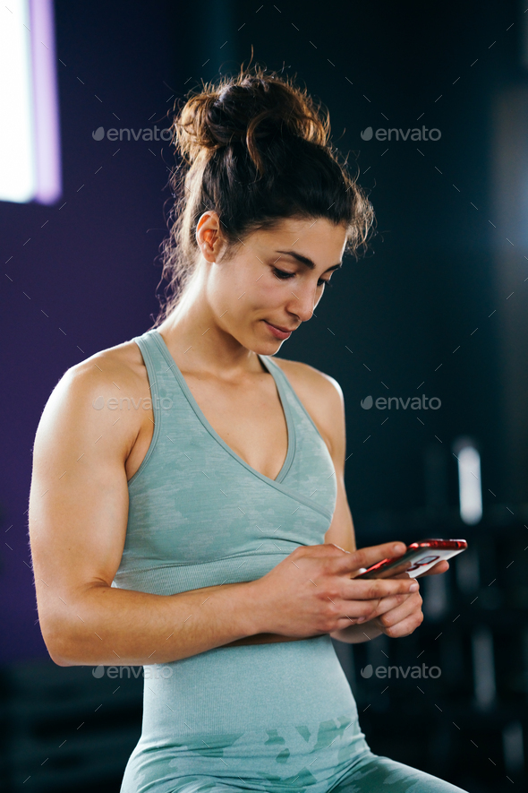 Woman consulting her training on her smartphone sitting in a jump box