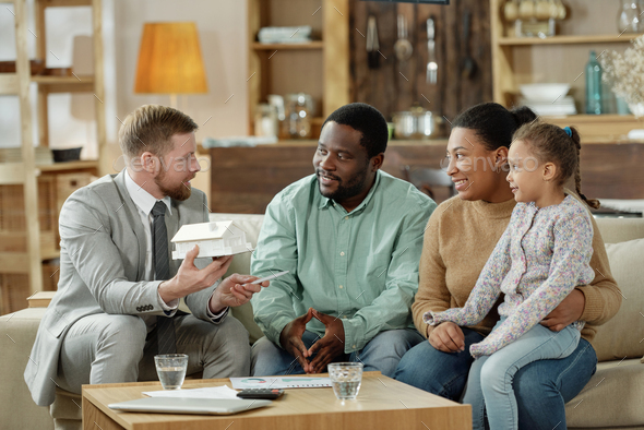 Adult counselor talking to ethnic family at home