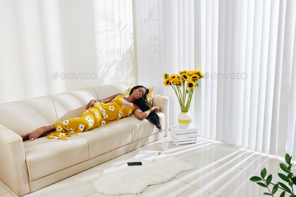 Young Black woman sleeping on sofa
