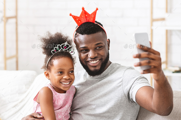 Joyful afro family having fun at home, taking selfie