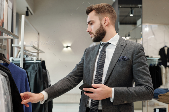 Businessman choosing clothes in store