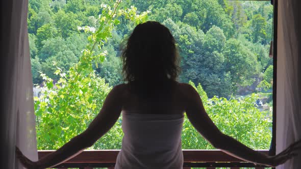 Woman Opening Curtains and Window alt