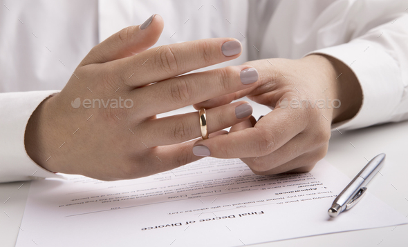 Close up view of hand taking off engagement ring