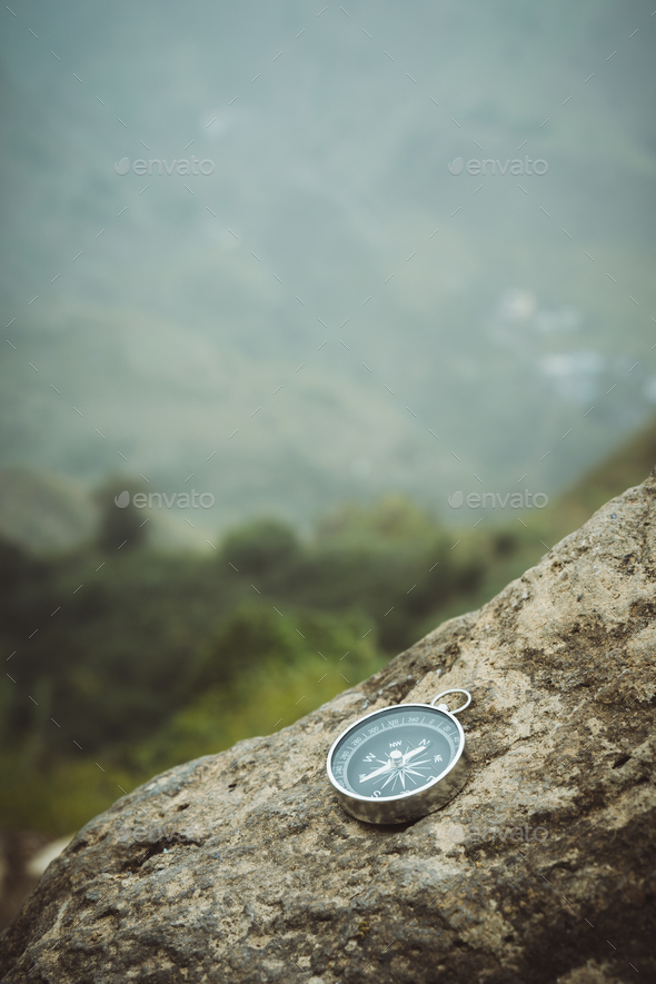 Trakking concept - Analogical Compass laying on the rocks with mountains in background - Stock Photo - Images