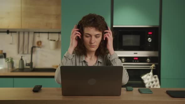 Young 20s Adult Student Picking Up Headphones and Listen to Music alt