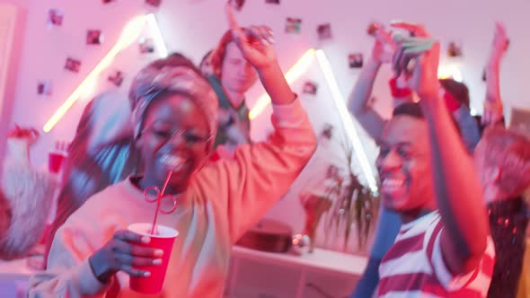 Joyous African American Couple Dancing with Friends at Home Party alt