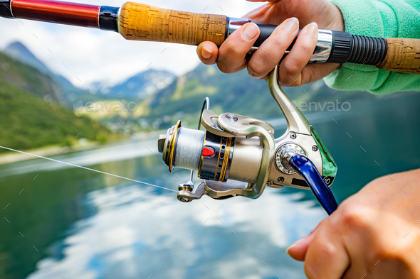 Woman fishing on Fishing rod spinning in Norway. Stock Photo by cookelma