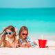 Two little happy girls have a lot of fun at tropical beach playing together