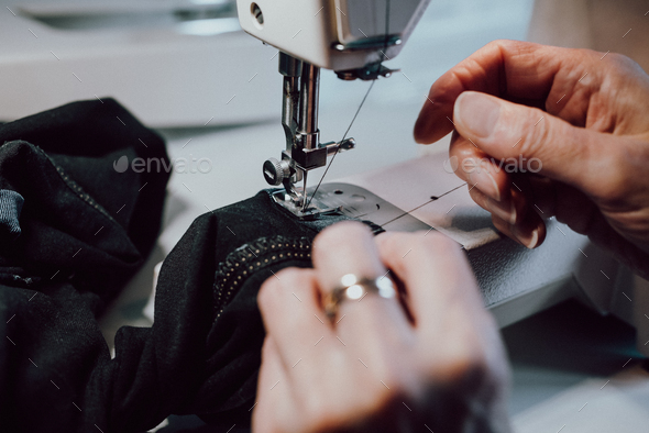 woman sews on the sewing machine - Stock Photo - Images