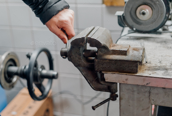 the mechanic uses the vise in the garage - Stock Photo - Images