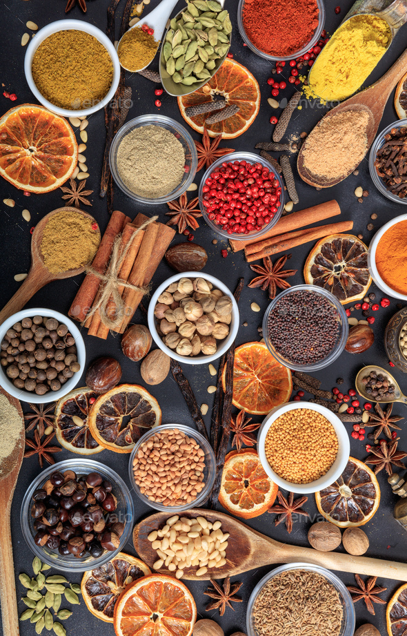 Spices and herbs flat lay, black background, top view. Stock Photo by rawf8