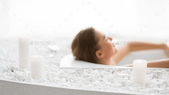 Total relaxation. Woman enjoying hot bath with candles