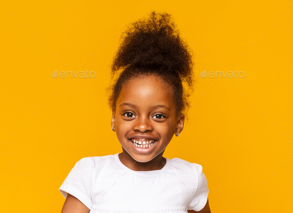 Portrait of african little girl smiling over yellow background Stock Photo  by Prostock-studio