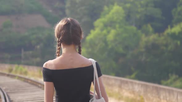 Girl in Black Top Walks To Railway Among Nature Closeup alt