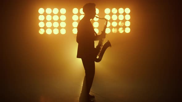 Silhouette Jazz Musician Playing Saxophone in Spotlights alt