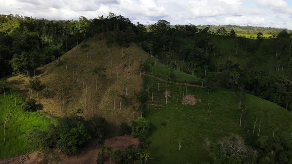 Farmland in the center of Costa Rica's northern province Alajuela. Drone approaching ridge of a hill alt