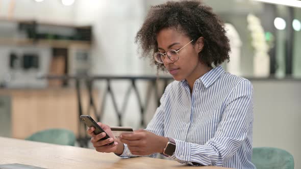 Successful Online Payment By African Businesswoman on Smartphone in Office  alt