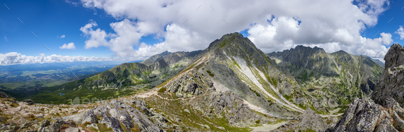 Mountain stone range peak against blue cloudy sky - Stock Photo - Images