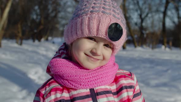 Joyful Little Child Girl Looking at Camera Smiling Fooling Around Making Faces in Winter Park alt