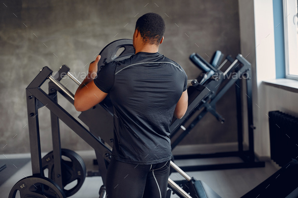 A handsome black man is engaged in a gym Stock Photo by prostooleh