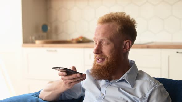 Smiling Young Redhead Man Using Convert Voice Into Text Mobile App