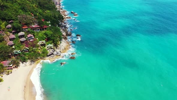 Natural flying tourism shot of a white sand paradise beach and blue ocean background in 4K alt