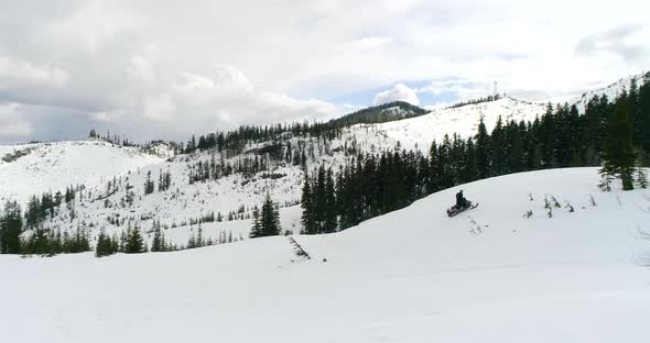 Winter Snowmachine Riding Up Mountain Slope Bird Flying Above Aerial View alt