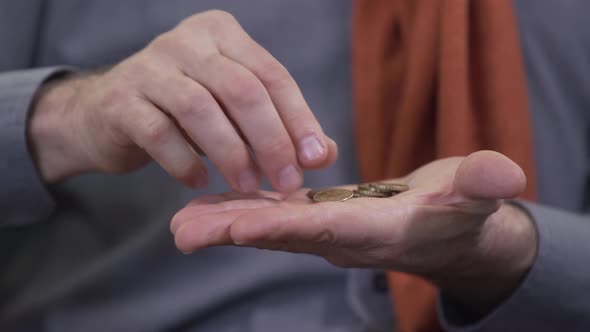 Extreme Close-up of Mature Caucasian Hands Examining Coins. Unrecognizable Numismatist Holding Money alt