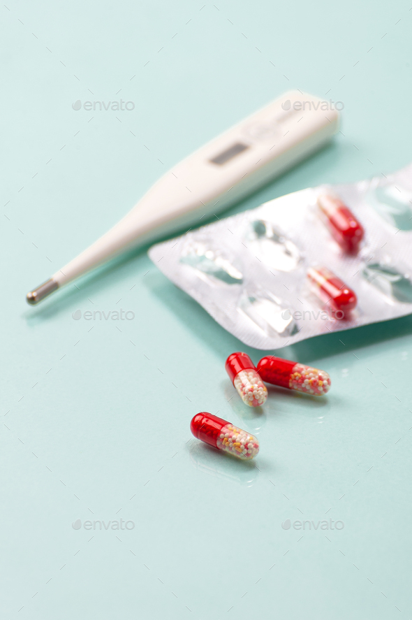 Antibiotic and thermometer. Highly blurred background photo. - Stock Photo - Images