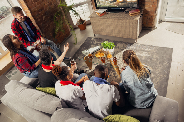 Excited group of people watching sport match at home