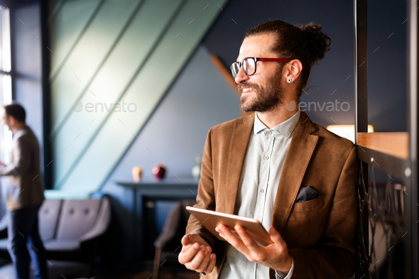 Portrait of happy young business male executive using digital tablet