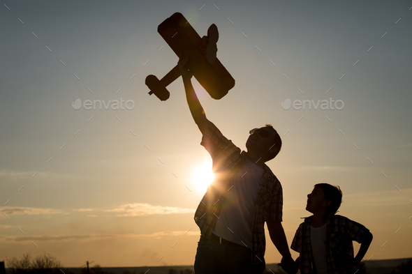 Father and son playing with cardboard toy airplane - Stock Photo - Images