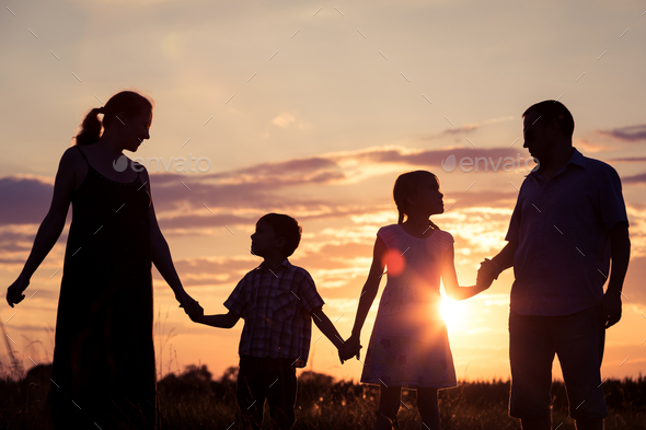 Happy family standing on the field at the sunset time. They build a house. - Stock Photo - Images