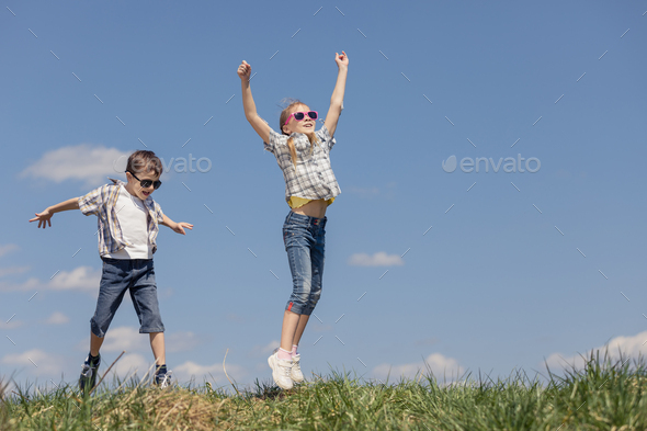 Brother and sister playing on the field - Stock Photo - Images