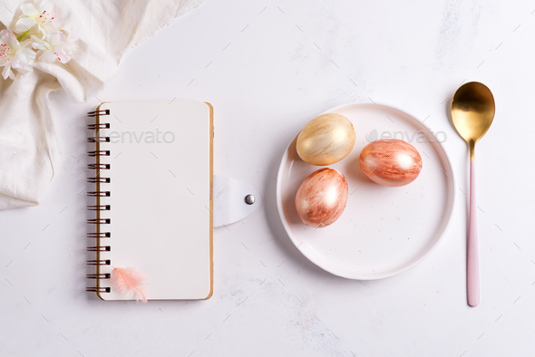 Congrats card with blank notebook mock-up, handmade painted eggs on a plate, golden spoon on a light