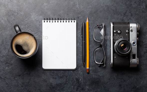 Office desk table with notepad, camera and coffee Stock Photo by karandaev