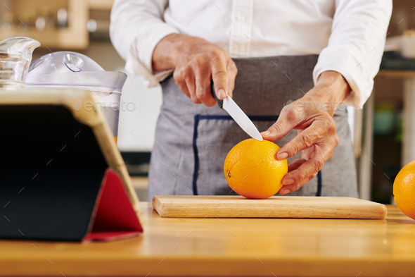 Man cutting fresh orange