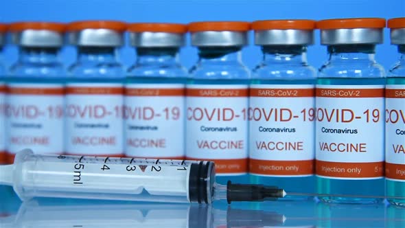 Glass Medicine Bottle With Covid-19 Vaccine And Syringe Injection.