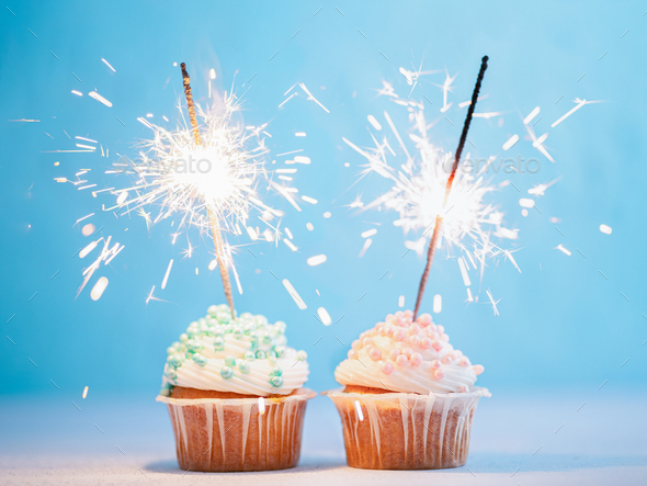 Two cupcakes decorated with sparklers