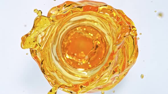 Super Slow Motion Shot of Oil Vortex Splash Liquid Isolated on White Background at 1000Fps alt