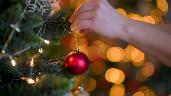 Female hands decorating christmas tree
