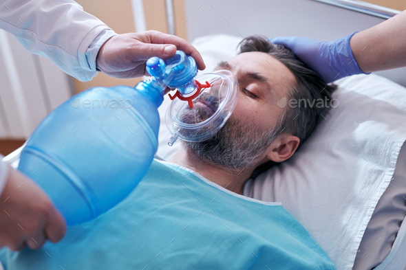 Placing bag valve mask on face of patient