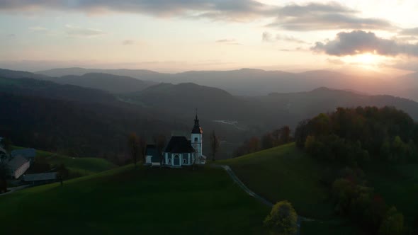 Amazing Beautiful Aerial View of the Hills, Colorful Forest and the Sv Sobota Church. Slovenia
