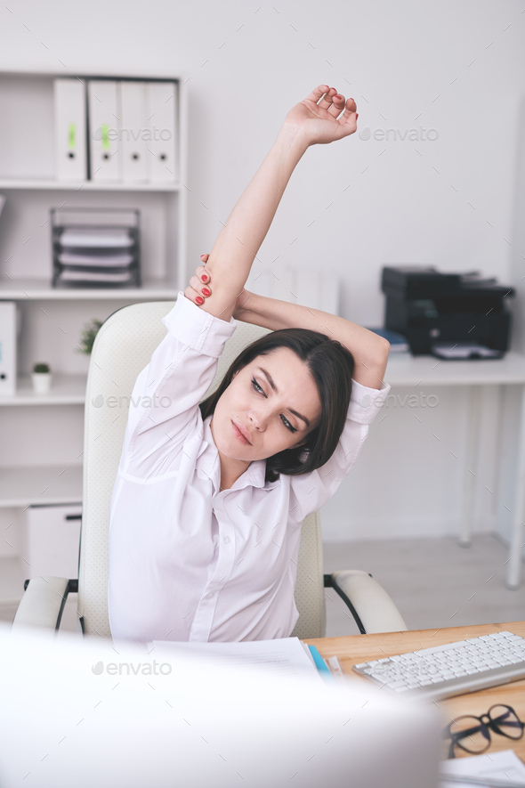Businesswoman stretching at desk